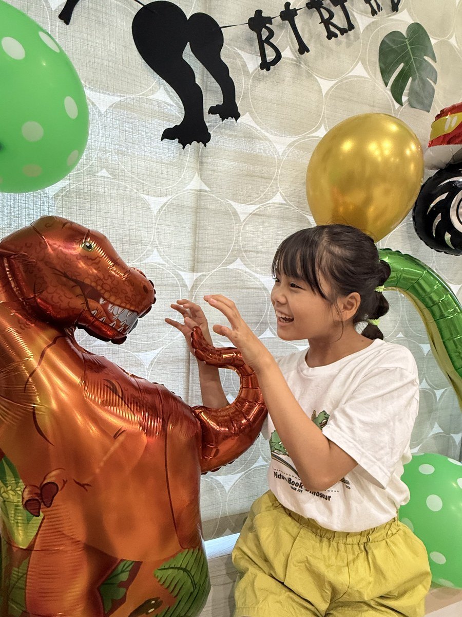窓辺の段に恐竜バルーンを並べた誕生日の飾り付け実例