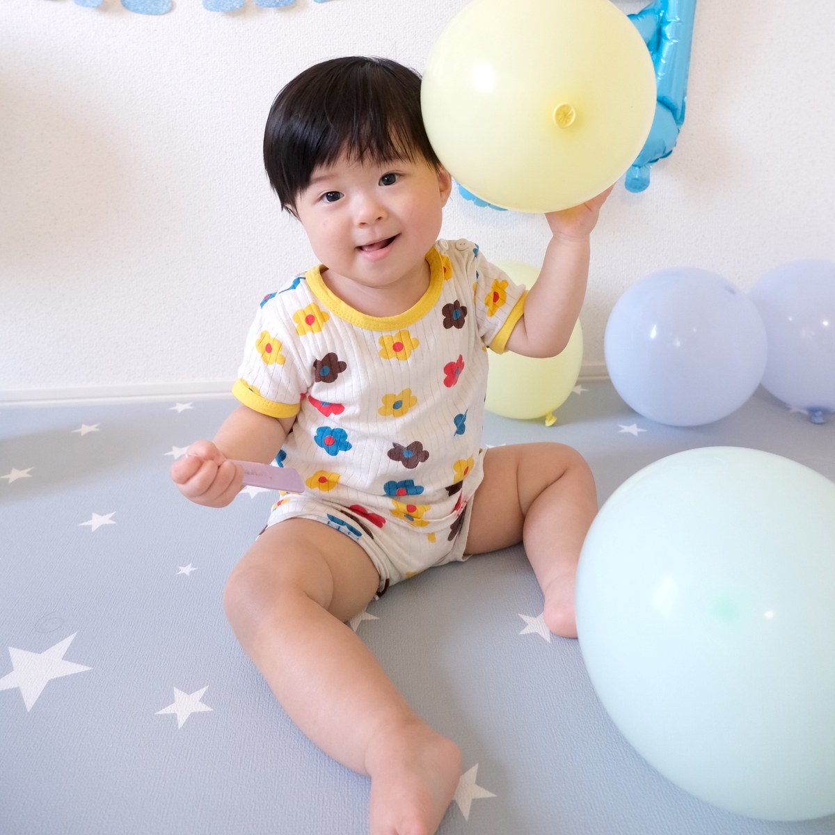 黄色いゴム風船を持ち上げて笑うお子さん（撮影：コハ丸さん）
