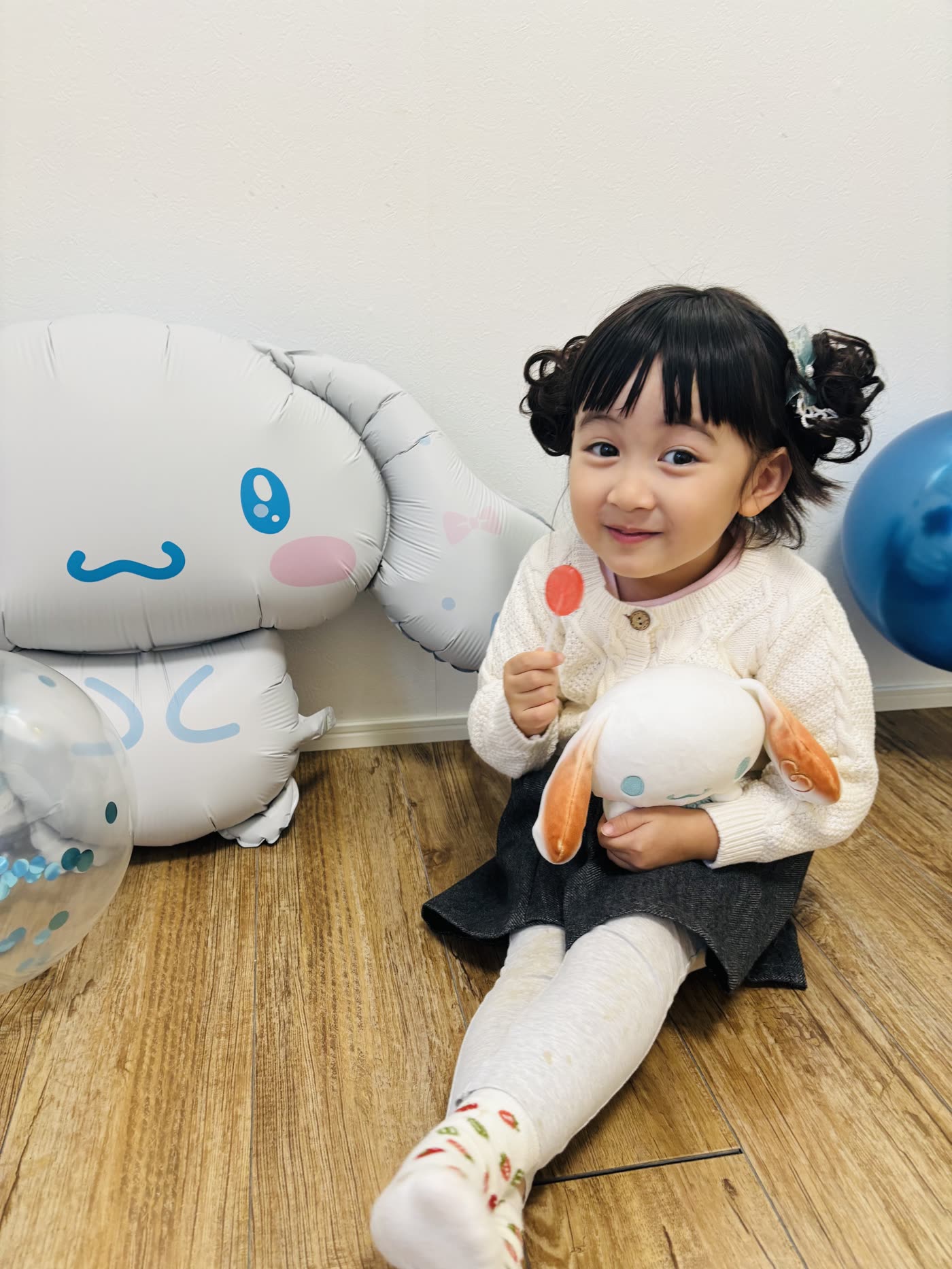 シナモロールのバルーンとぬいぐるみを抱えた女の子