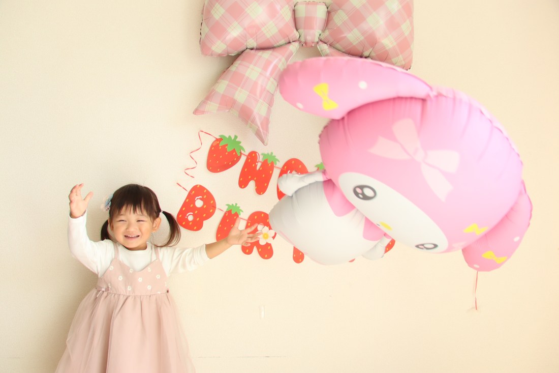 マイメロディのバルーンを頭の上に持ち上げて笑うお子さん（撮影：RIMIさん）