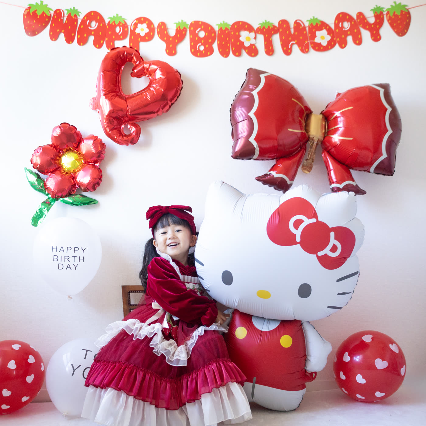 ハローキティのバルーンに抱きつく女の子
