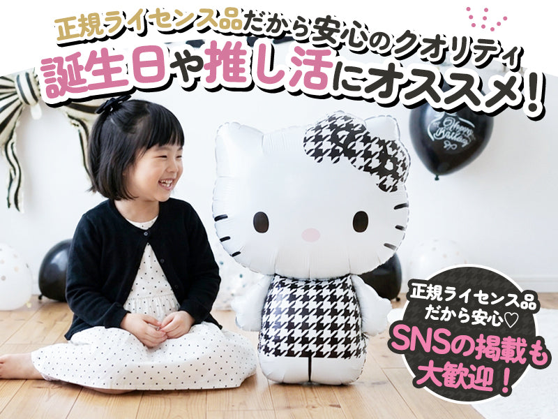 モノクロのハローキティ バルーンと並んで座るお子さん